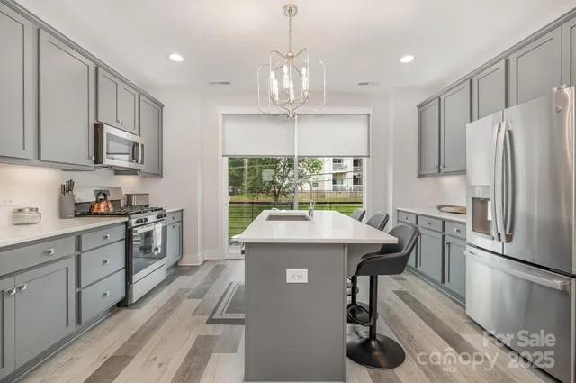 a kitchen with kitchen island granite countertop stainless steel appliances a stove and a refrigerator