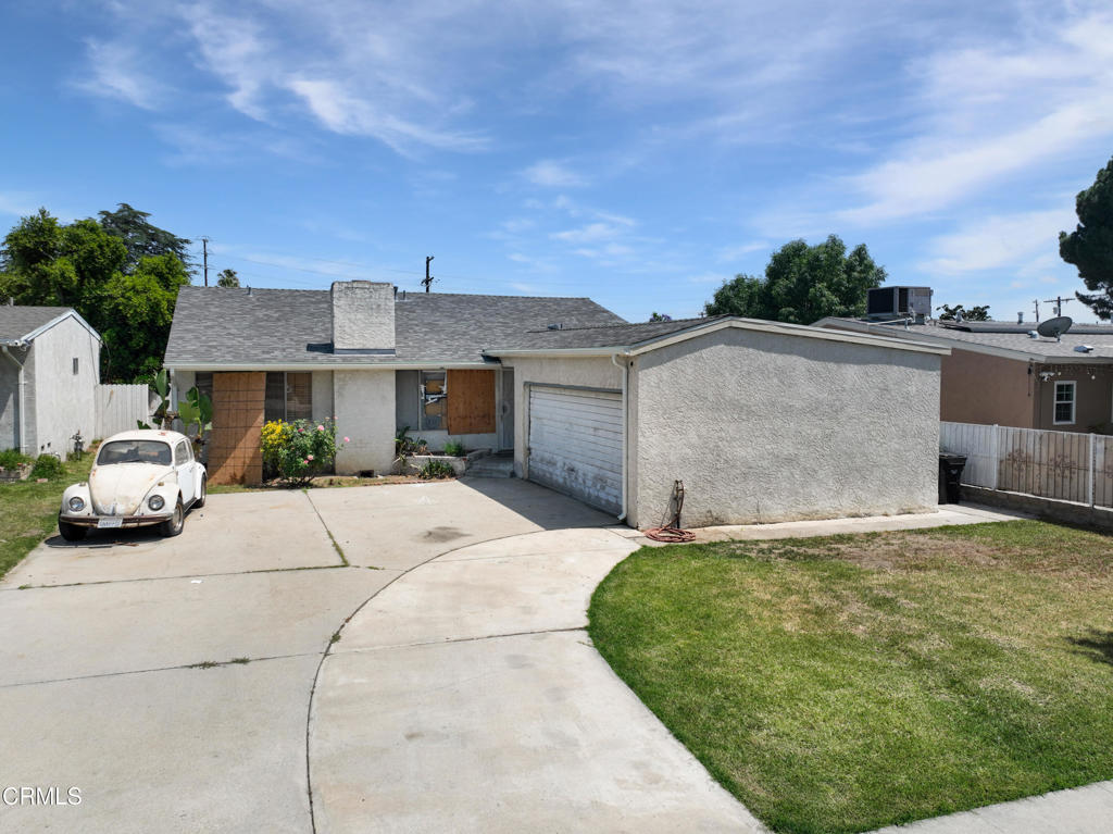 14306 Aztec Street Sylmar, CA 91342 - Photo 2 of 21 a view of a white house with a yard plants and large tree