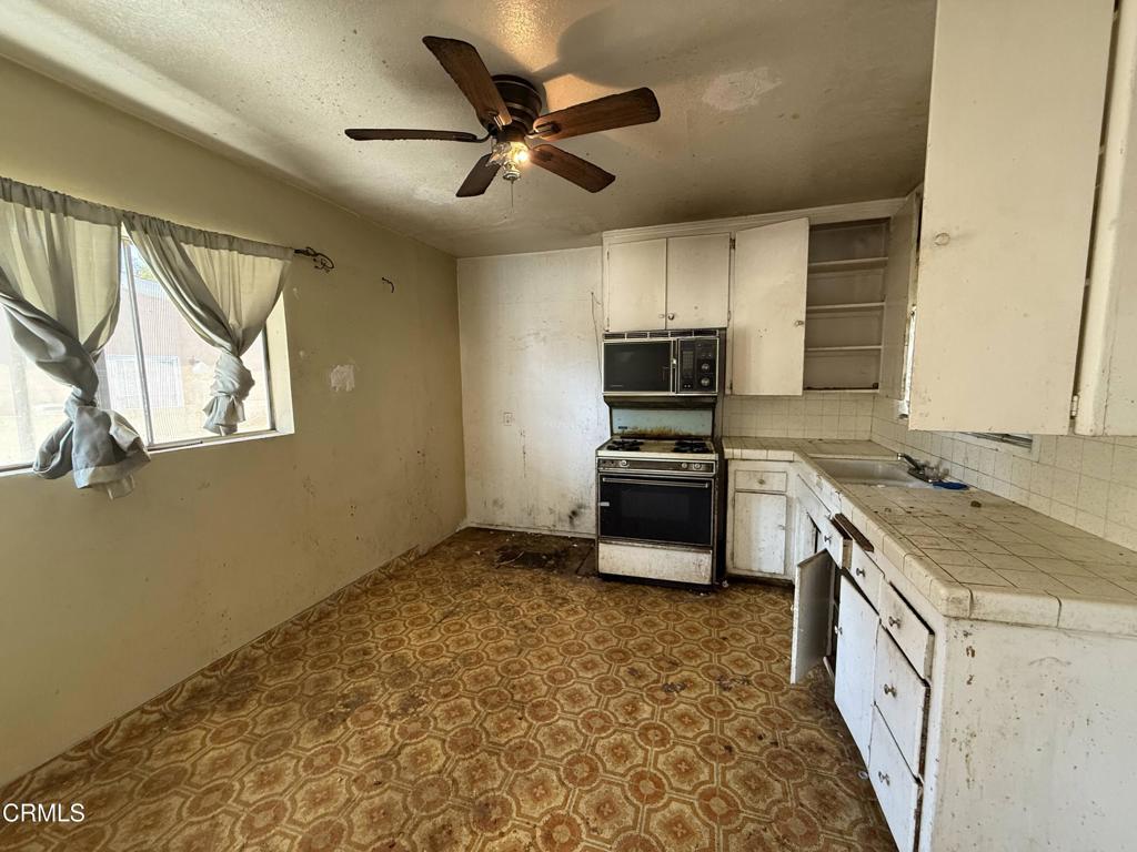 14306 Aztec Street Sylmar, CA 91342 - Photo 7 of 21 a kitchen with a stove a sink and a refrigerator