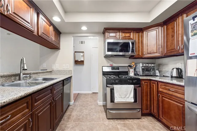 a kitchen with stainless steel appliances granite countertop a stove and a refrigerator