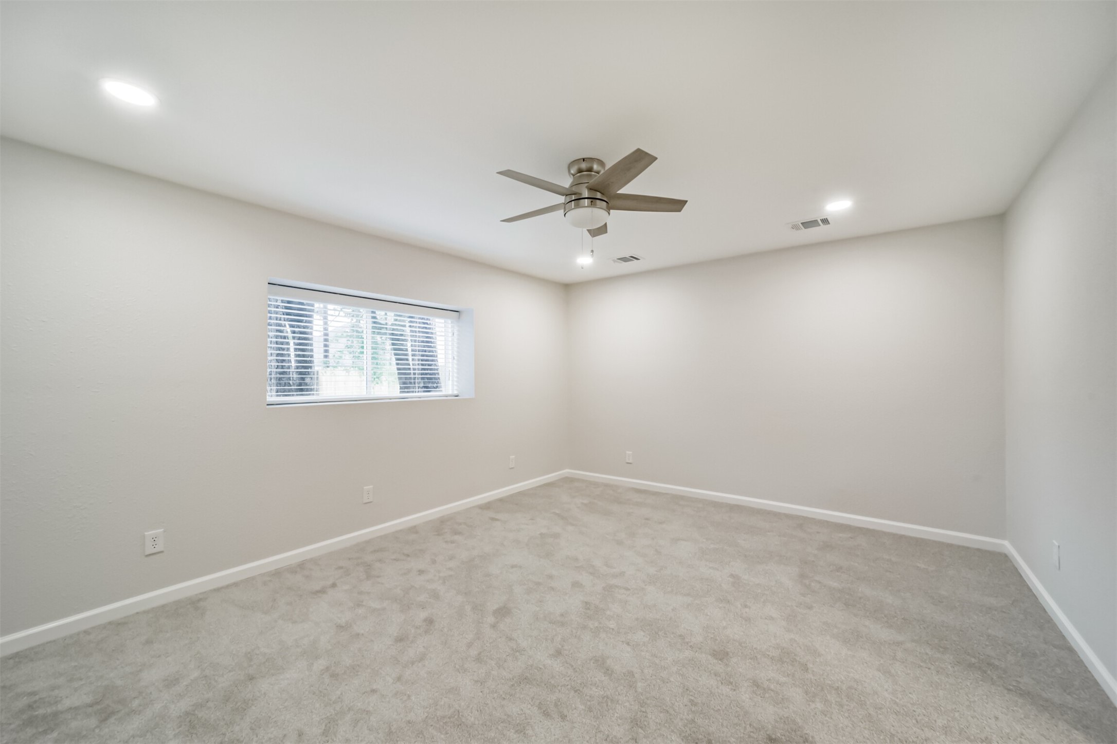 15610 Ripplewind Lane Houston, TX 77068 - Photo 19 of 44 an empty room with a window and a fan