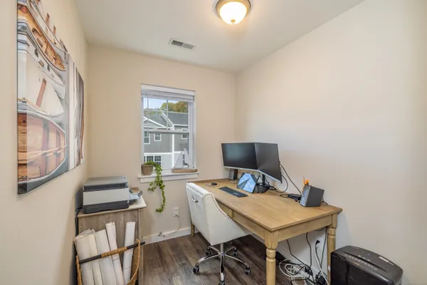 a view of a workspace with furniture and a window