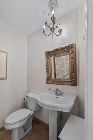 a bathroom with a toilet a sink and mirror