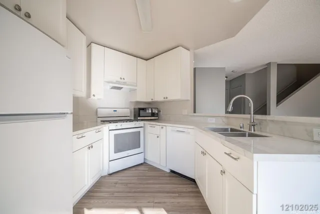 a kitchen with cabinets appliances and a sink