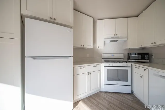 a kitchen with cabinets stainless steel appliances and a counter space