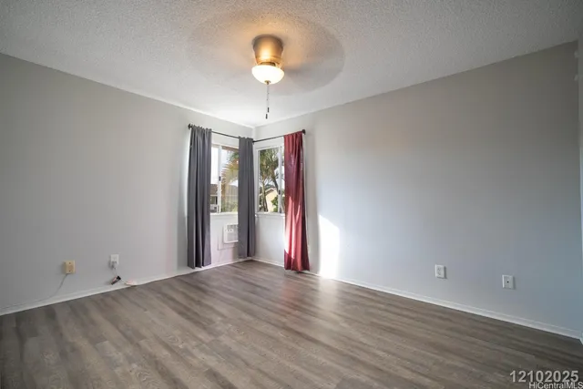 an empty room with wooden floor and chandelier