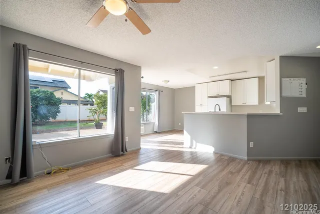 a view of a livingroom with wooden floor and a ceiling fan