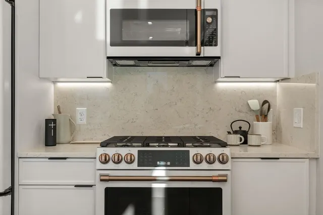 a stove top oven sitting inside of a kitchen