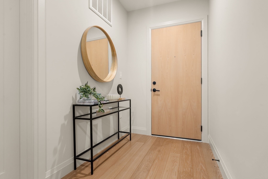 100 Lincoln Street, Unit 403 Boston, MA 02135 - Photo 15 of 23 a view of a room with wooden floor and white walls