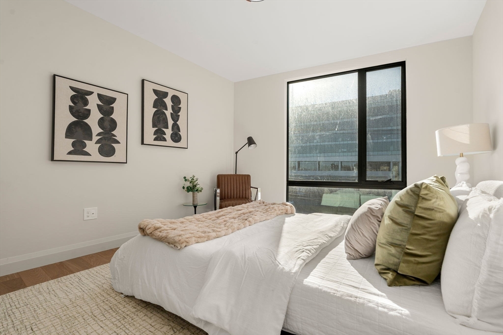 100 Lincoln Street, Unit 403 Boston, MA 02135 - Photo 4 of 23 a bedroom with a bed and a large window