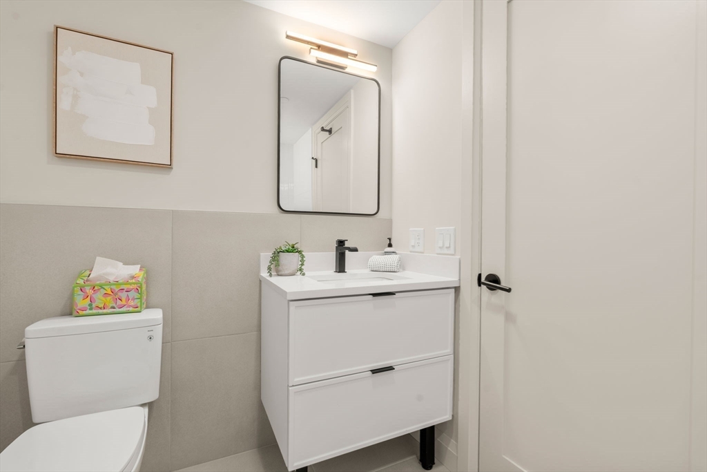 100 Lincoln Street, Unit 403 Boston, MA 02135 - Photo 6 of 23 a bathroom with a toilet sink vanity and mirror