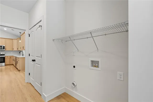 a view of a kitchen with white cabinets and wooden floor