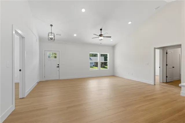 a view of an empty room with a window and wooden floor