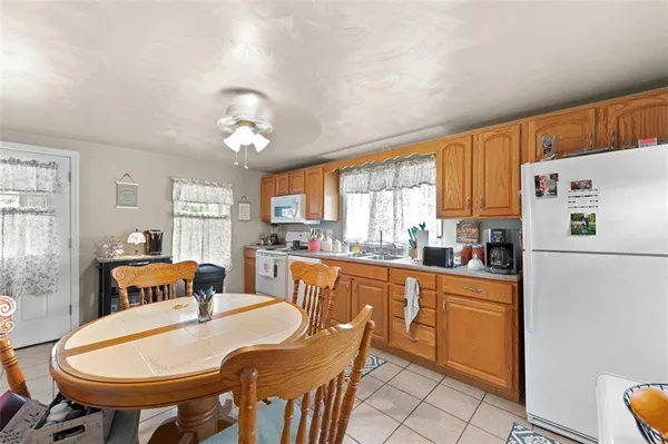a kitchen with stainless steel appliances granite countertop a dining table chairs and a refrigerator