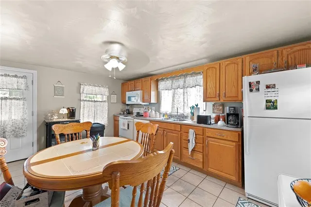 a kitchen with stainless steel appliances granite countertop a dining table chairs and a refrigerator