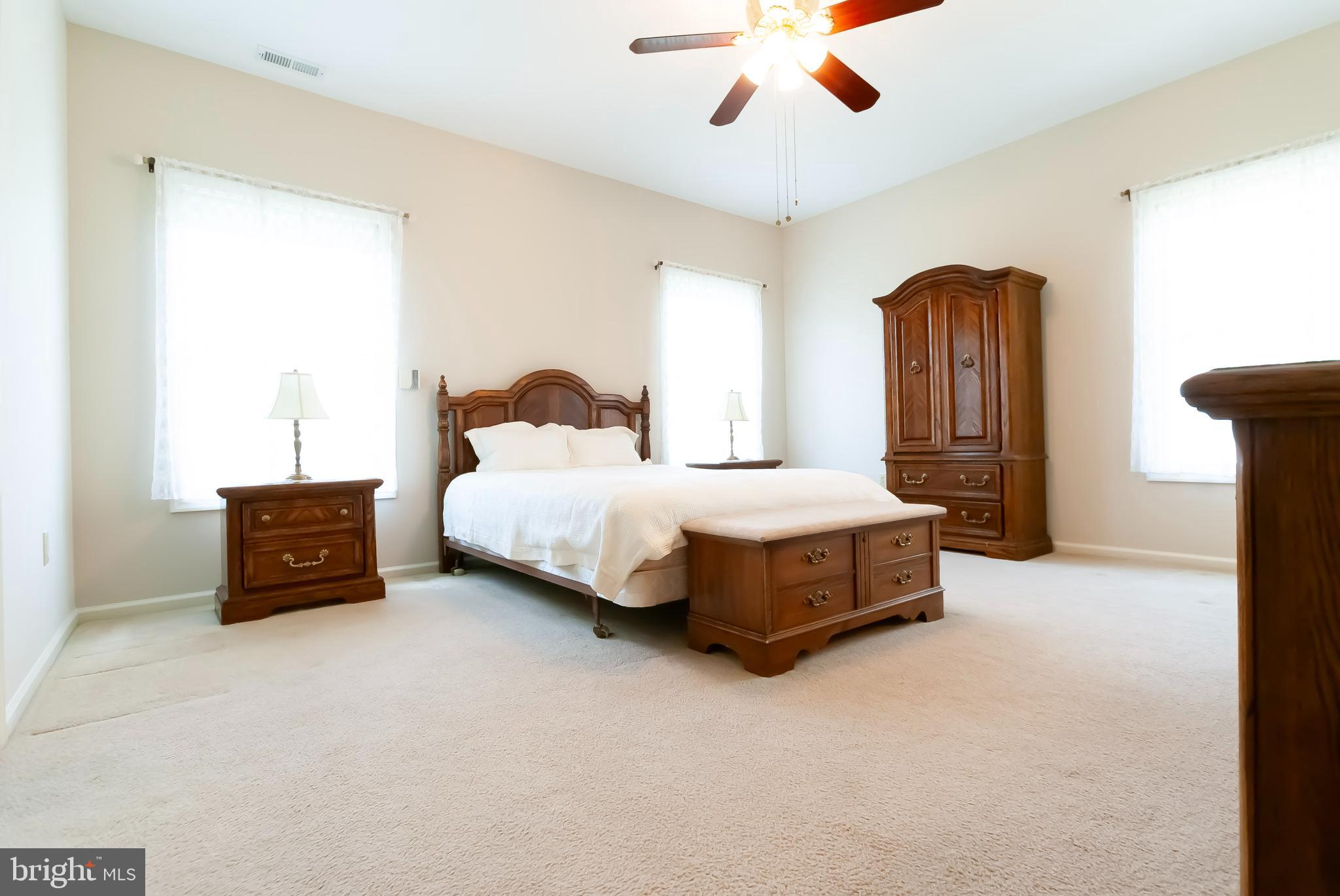 89 Lantern Lane Columbus, NJ 08022 - Photo 20 of 55 a spacious bedroom with a bed and a chandelier