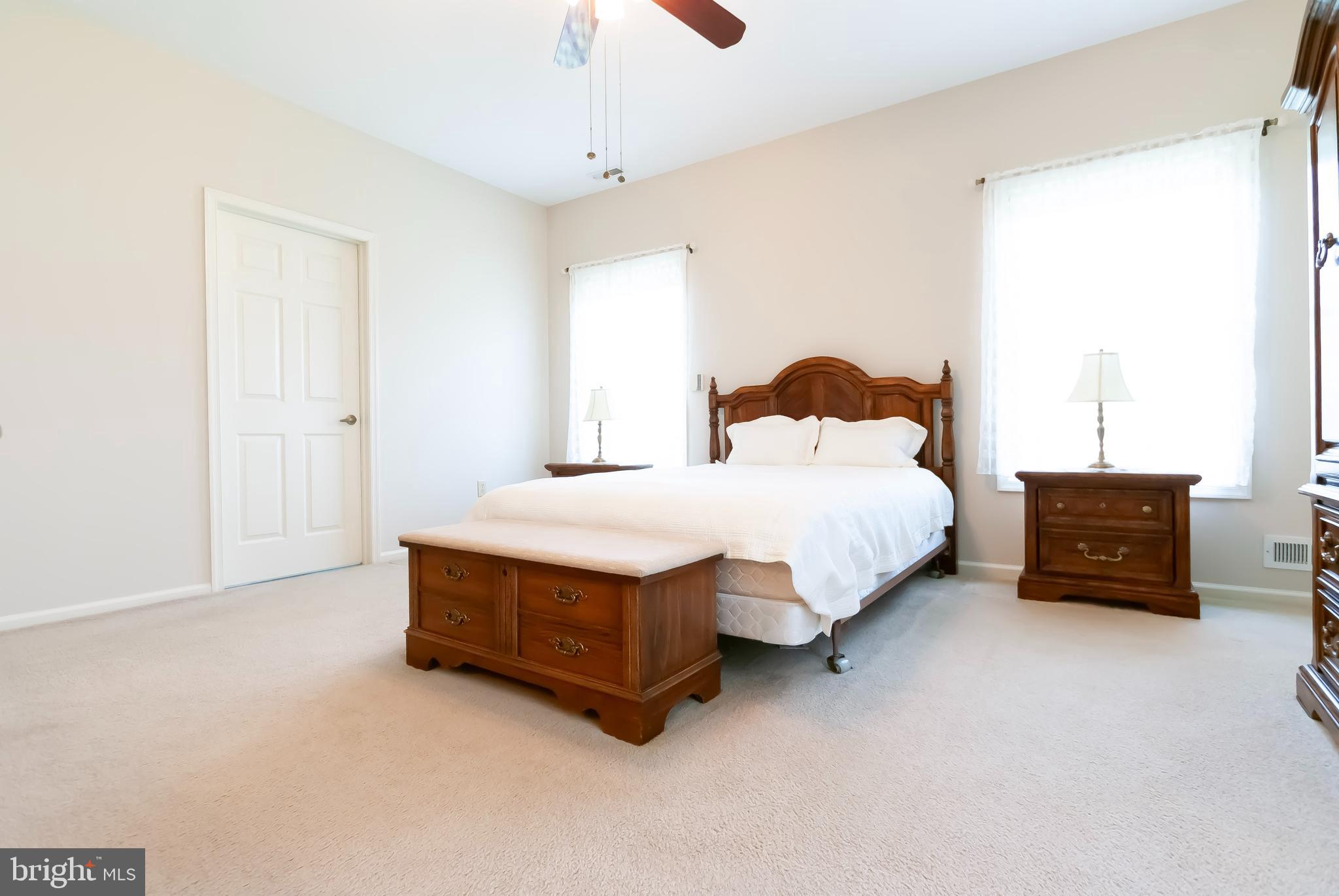 89 Lantern Lane Columbus, NJ 08022 - Photo 22 of 55 a spacious bedroom with a bed and a chandelier
