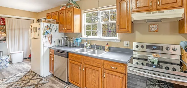 a kitchen with stainless steel appliances granite countertop a sink and cabinets