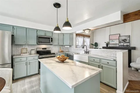 a kitchen with a sink a stove a refrigerator and cabinets