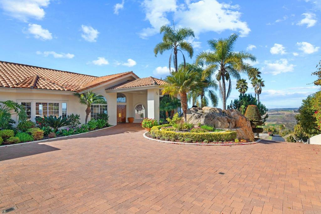 1402 Vista De Lomas Bonsall, CA 92003 - Photo 6 of 56 a view of a white house with a yard and potted plants