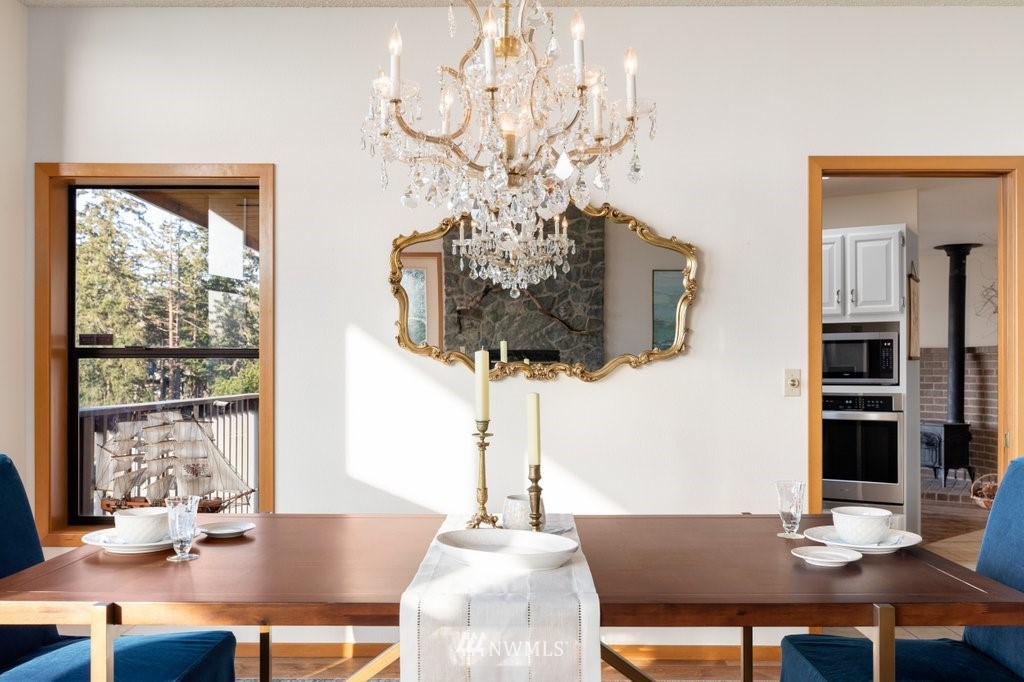 1860 East Hunskor Road Oak Harbor, WA 98277 - Photo 12 of 40 a view of a dining room with furniture a chandelier and wooden floor