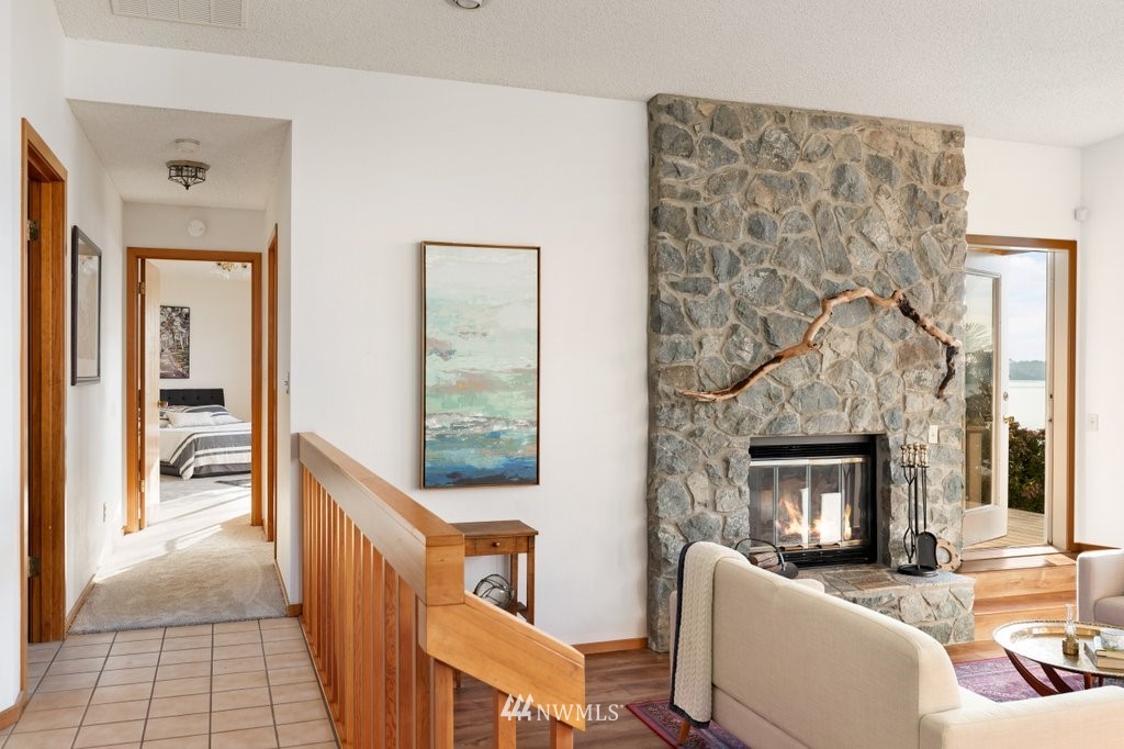 1860 East Hunskor Road Oak Harbor, WA 98277 - Photo 19 of 40 a living room with furniture a fireplace and a floor to ceiling window