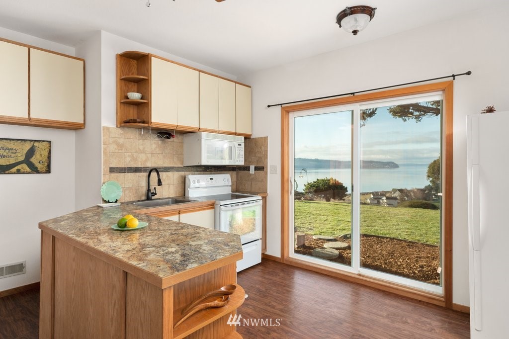 1860 East Hunskor Road Oak Harbor, WA 98277 - Photo 34 of 40 a kitchen with granite countertop wooden cabinets and a counter top space