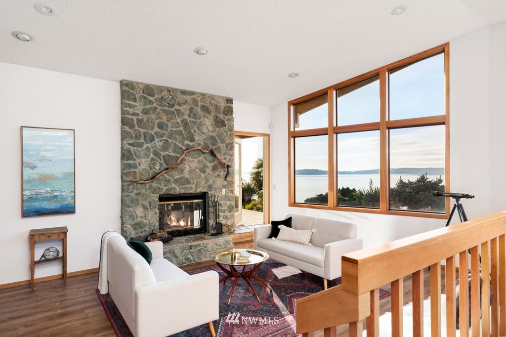 1860 East Hunskor Road Oak Harbor, WA 98277 - Photo 7 of 40 a living room with furniture a fireplace and a floor to ceiling window