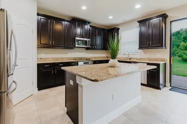 a kitchen with stainless steel appliances granite countertop a sink counter space and a window