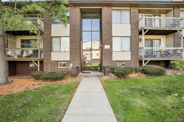 a view of a brick house with a yard and potted plants