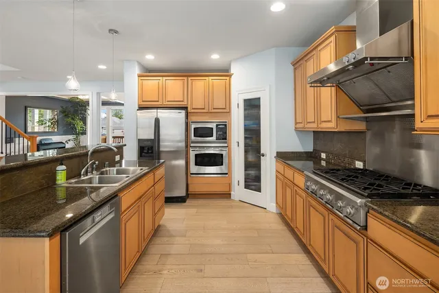a kitchen with stainless steel appliances granite countertop a sink stove and refrigerator