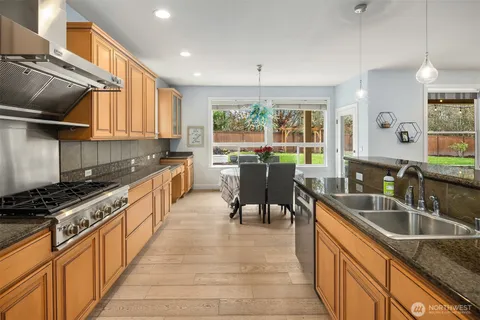 a kitchen with granite countertop a sink stove and cabinets