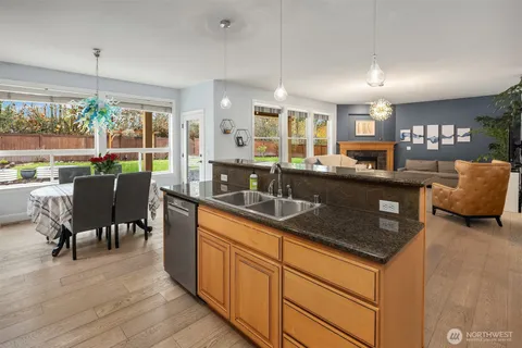 a kitchen with stainless steel appliances granite countertop sink stove and wooden cabinets