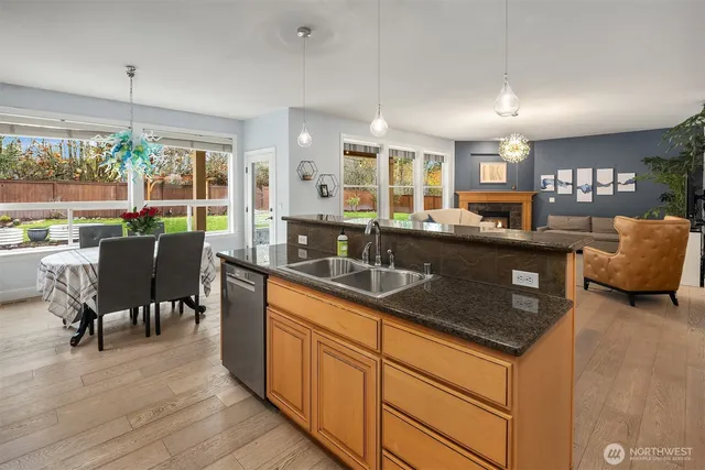 a kitchen with stainless steel appliances granite countertop sink stove and wooden cabinets