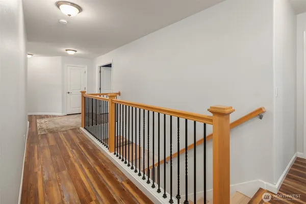 a view of a hallway with wooden floor