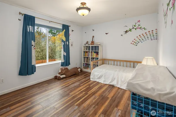 a bedroom with a bed and wooden floor