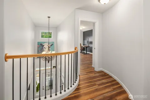a view of a hallway with wooden floor and stairs