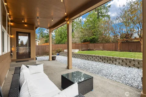 a view of a patio with couches table and chairs and potted plants