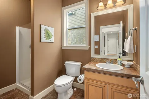 a bathroom with a granite countertop toilet a sink and a mirror