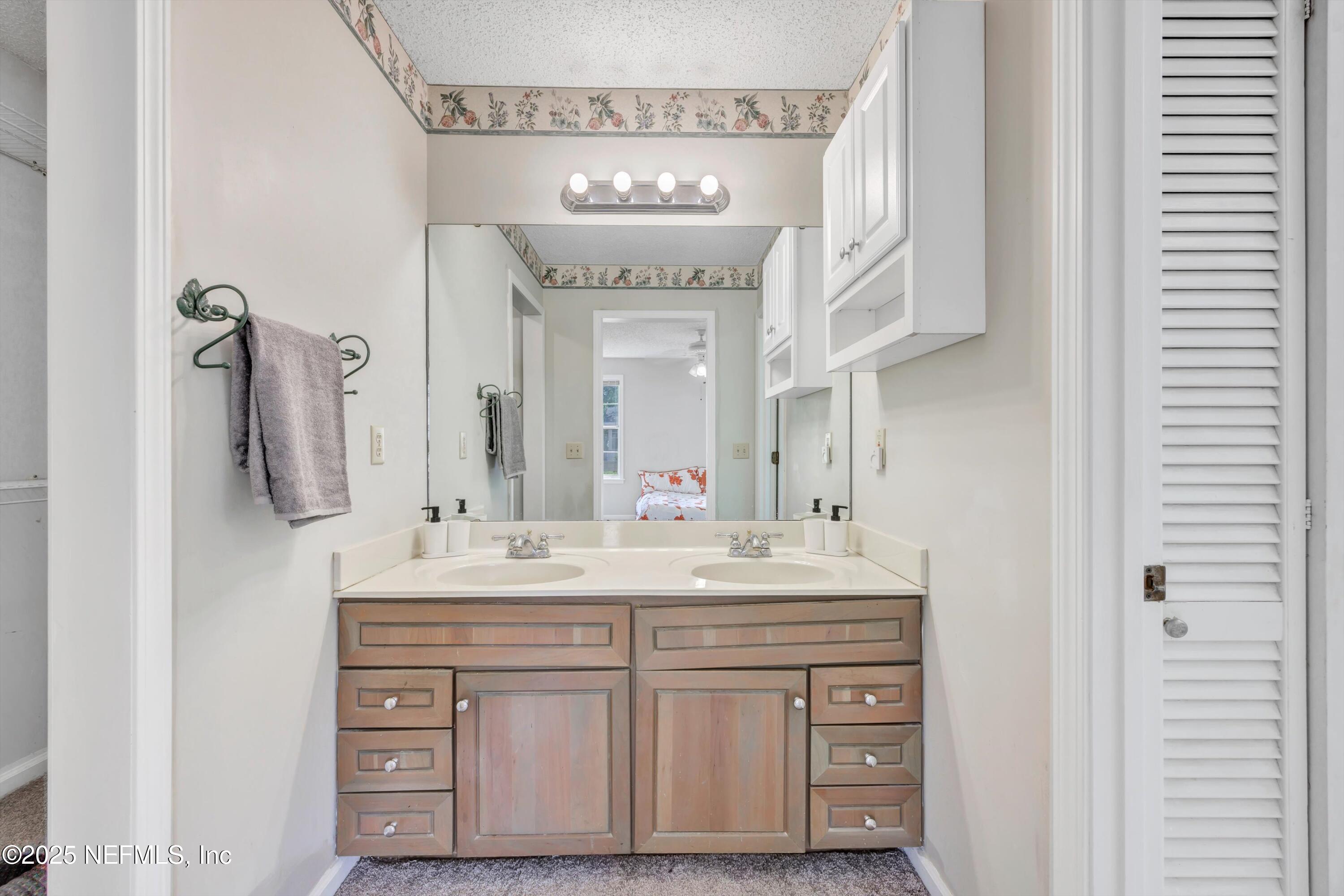 1425 Pinetree Road Jacksonville, FL 32207 - Photo 27 of 39 a bathroom with a sink vanity and a mirror