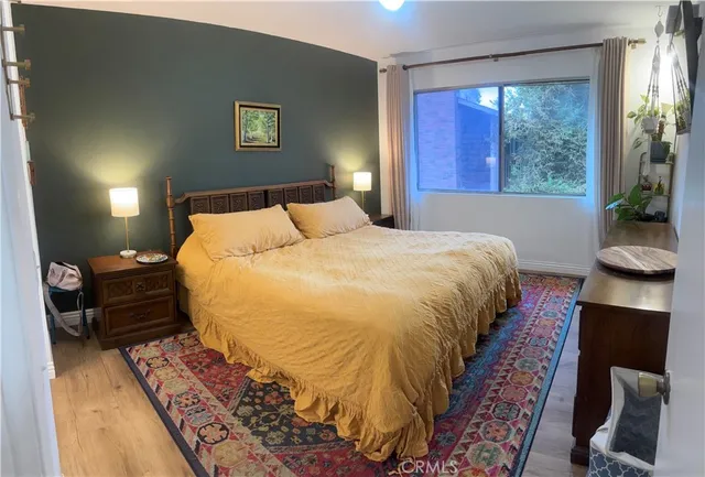 a bedroom with a bed and wooden floor