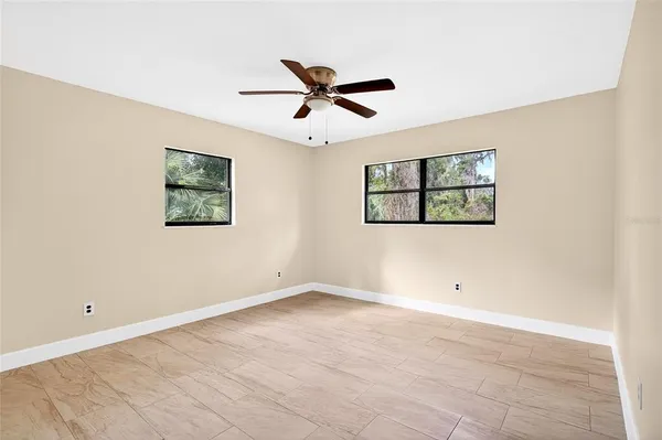 a view of a big room with carpet and a ceiling fan