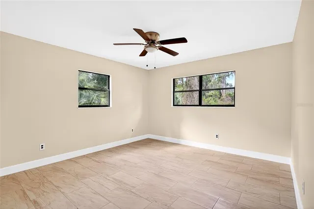 a view of a big room with carpet and a ceiling fan
