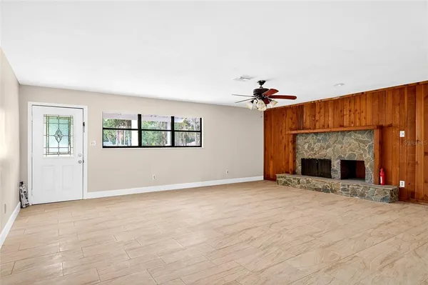 an empty room with windows and fireplace