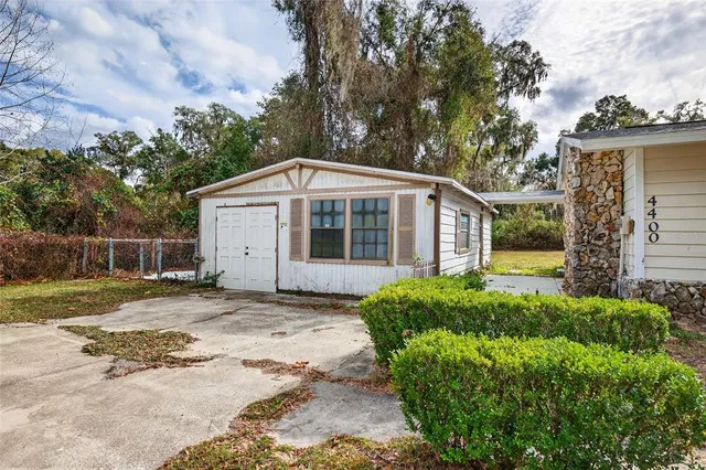 a view of a house with backyard and trees