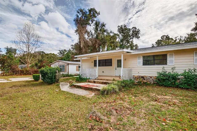 a view of a house with backyard and sitting area