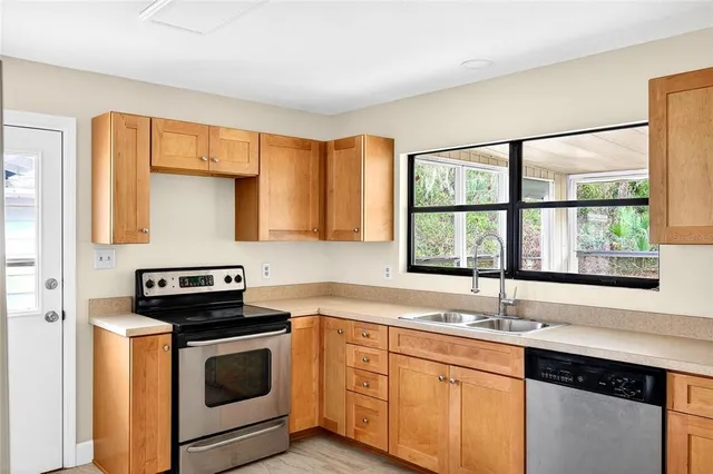 a kitchen with stainless steel appliances a stove sink and window