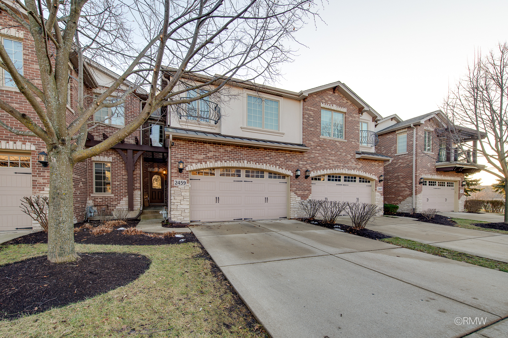 a view of a house with a small yard and a large tree