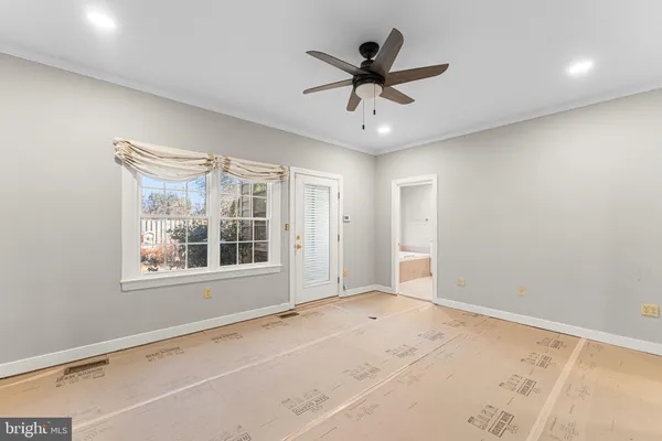 a view of a big room with wooden floor and windows