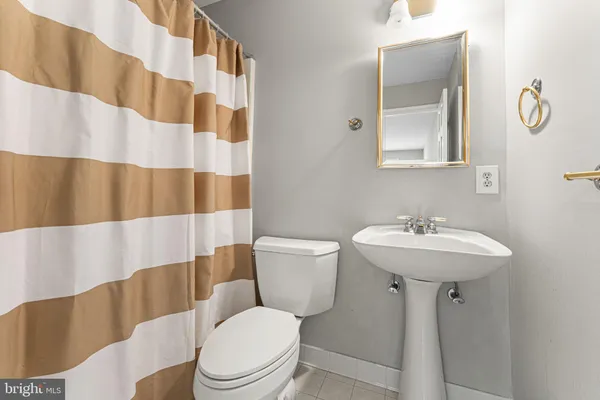 a bathroom with a sink a toilet and shower curtain